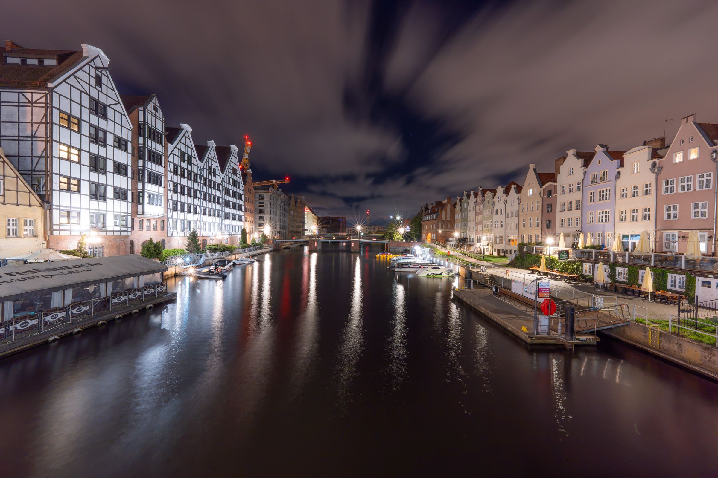 Altstadt von Danzig bei Nacht mit beleuchteten Giebelhäusern und Spiegelung im Fluss
